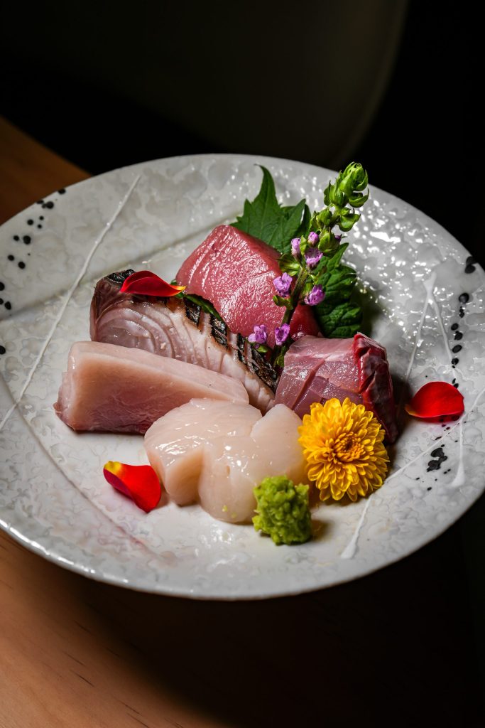 Seasonal sashimi of tuna, seared fish and scallop with fresh wasabi, shiso and chrysanthemum